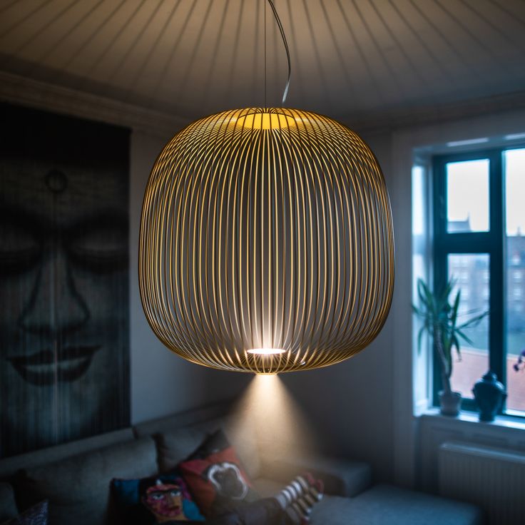 a living room with a couch and a lamp hanging from it's ceiling fixture