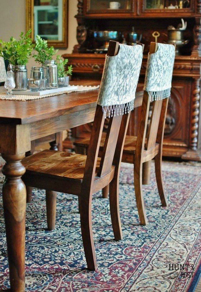 a dining room table with chairs and a rug on the floor