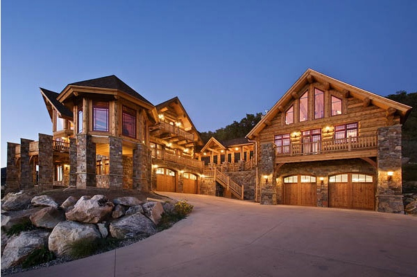 a large house with lots of windows on the front and side of it at night