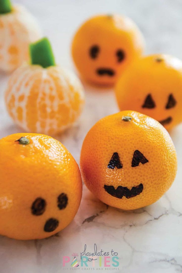 oranges with faces drawn on them sitting next to each other