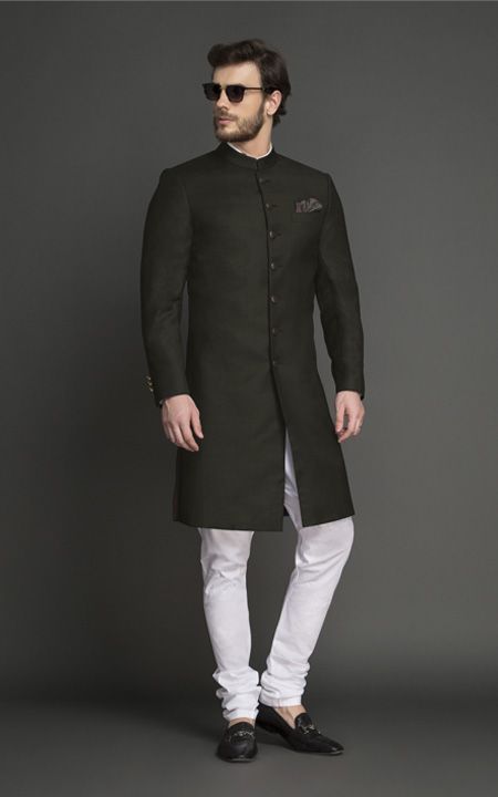 Olive Green is the color of the season and a trendy option for ceremonial wear. Tailored & designed for an ambitious modern man, this Achkan features interesting tailoring details over bling and will make you look every bit elegant and sophisticated. #weddingachkan #achkandesignsformen #achkanformen #achkangroom #indiangroom #achkan #indiangroomattire #instawedding #indianweddinginspiration #affordableluxury #mensfashion #menscustomsuit #classicsherwani #plainsherwani #olivegreenmenssuit Achkan For Men, Indowestern Outfits, Custom Suits Men, Waistcoat Designs, Mens Indian Wear, Sherwani For Men Wedding, Groom Dress Men, Indian Groom Wear, Wedding Dresses Men Indian