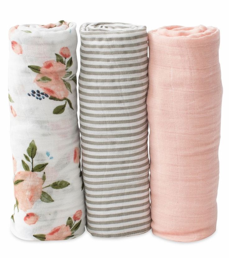 three baby swaddles in various colors and patterns, one pink, the other grey