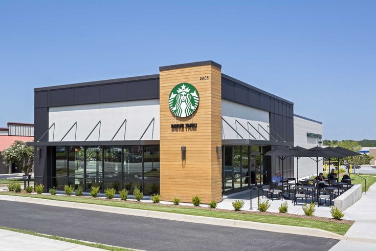 a starbucks coffee shop with tables and umbrellas outside