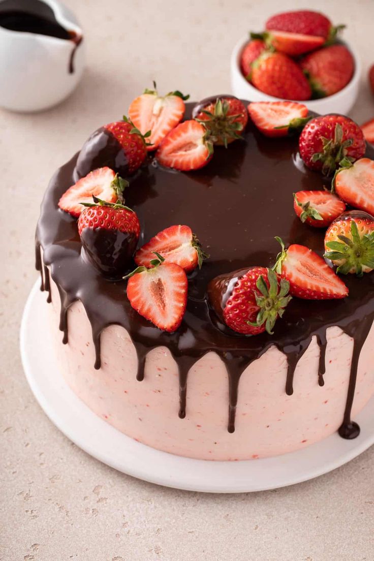 a chocolate covered cake with strawberries on top and drizzled in chocolate