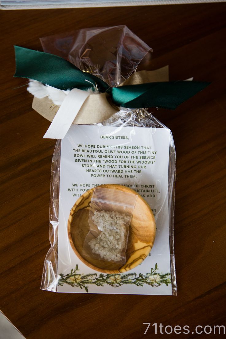 a piece of food wrapped in plastic sitting on top of a wooden table next to a green ribbon