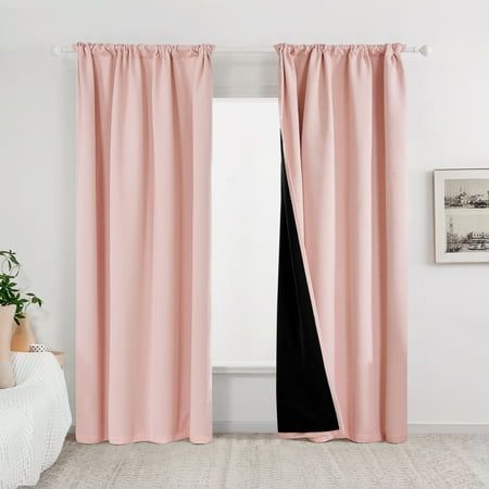 a pink curtain with black lining in a white room next to a bed and potted plant