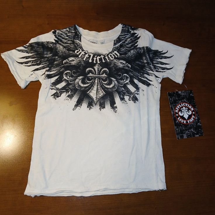 Nwt Affliction Venturous Toddler T-Shirt In White. Short Sleeve Ribbed Crew Neck Extremely Rare Black Graphic Print Raw Edges 100% Cotton Made In Usa Pit To Pit Measures 13" Length Measures 17" White Affliction Shirt, Cheap Alt Clothes, 2000s Fashion Shirts, Affliction Clothing Mens, Soft Affliction, Affliction Outfits, Affliction Clothing Women, Tiktok Clothes, Y2k Graphics