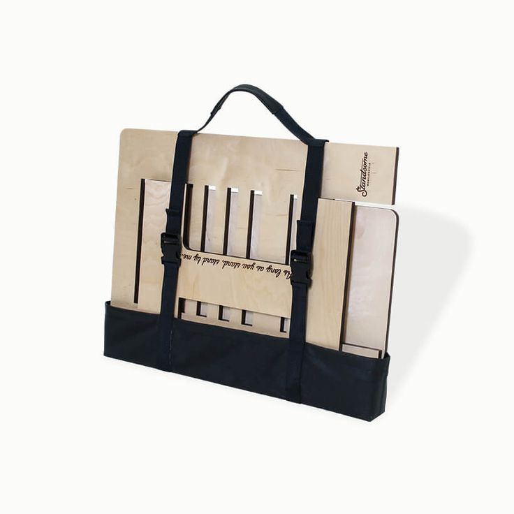 a black and white bag with two pieces of wood in it's handles, hanging on a wall