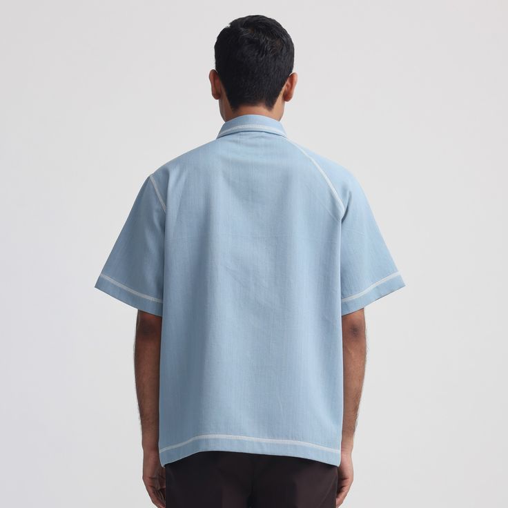 Symbolic patch pocket with Human symbol, Raglan sleeve on one side and regular sleeve on other, Contrast flatlock stitch,Half-sleeves. 100% Handwoven Cotton Blue Relaxed fit Model is 6’0″, Wearing size M Casual Collared Tops With Contrast Stitching, Blue Camp Shirt With Pockets And Relaxed Fit, Light Blue Cotton Shirt With Camp Collar, Blue Shirt With Patch Pockets For Spring, Blue Relaxed Fit Camp Shirt With Pockets, Spring Blue Shirt With Patch Pockets, Blue Spring Shirt With Patch Pockets, Blue Button-up Top With Patch Pockets, Casual Cotton Shirt With Contrast Stitching