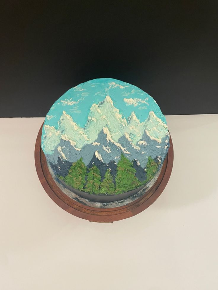 there is a cake decorated with mountains and trees