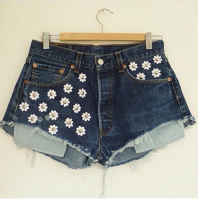 a pair of jean shorts with flowers on them