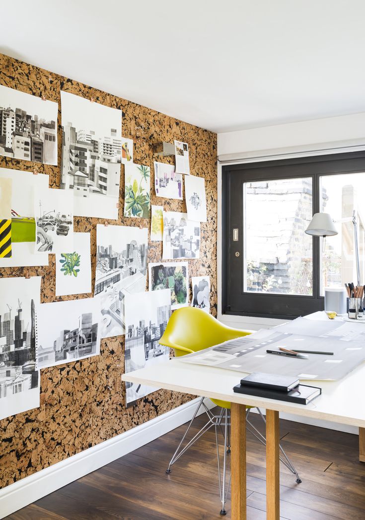 a desk with a lamp and some pictures on the wall