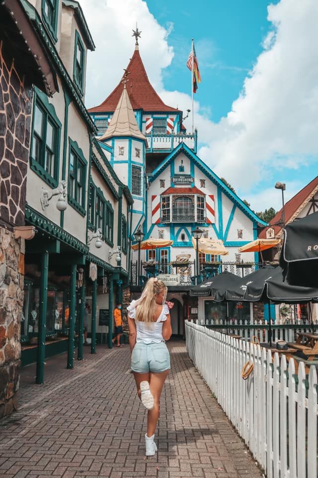 a woman walking down a street next to tall buildings