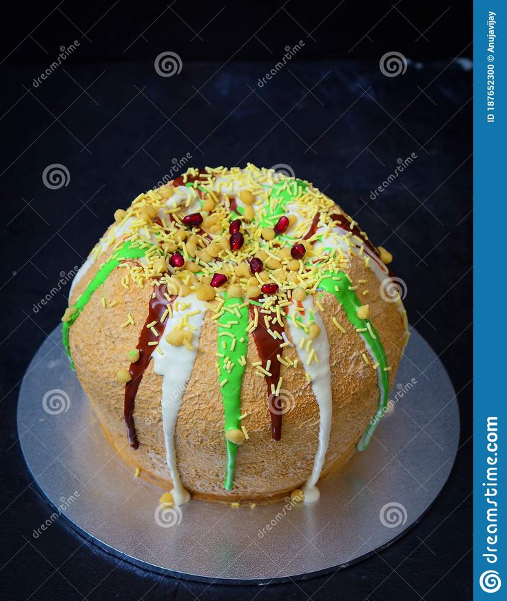 a cake decorated with icing and sprinkles on a silver platter