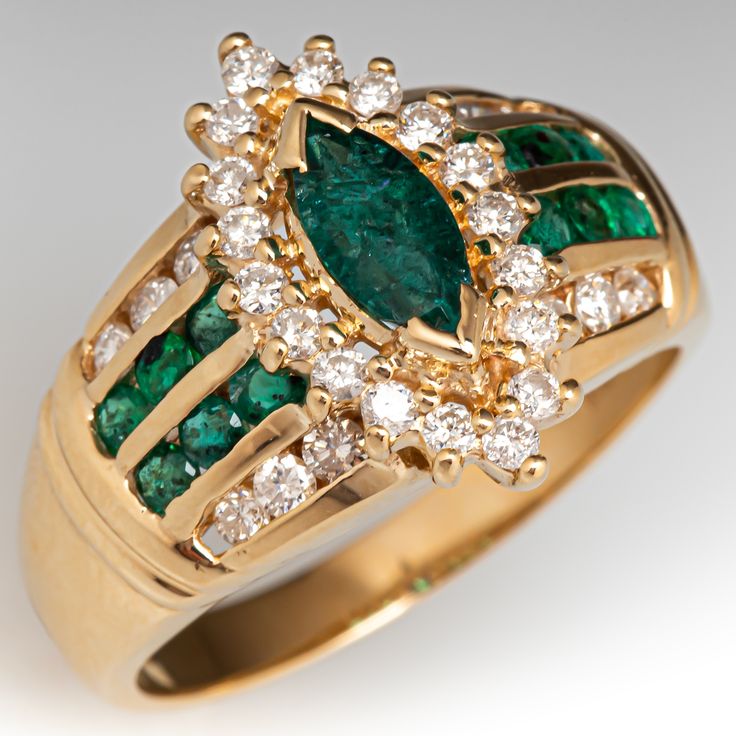 This pretty ring is centered with one (1) marquise cut emerald weighing 0.42 carats that is set in two (2) chevron shaped prongs. Surrounding the center stone are eighteen (18) round brilliant cut diamonds that are all prong set. The shoulders of the ring each contain six (6) round brilliant cut diamonds that are channel set and six (6) round cut emeralds that are also channel set. The ring measures 17.0mm at the top, rises 7.8mm above the finger, tapering to 3.0mm wide and 1.0mm thick at the base of the shank. It is currently a size 10. Two of the diamonds are lightly chipped. Diamond Emerald Ring, Pretty Ring, Swirl Ring, Emerald Diamond Ring, Pretty Rings, Channel Set, Size 10 Rings, Marquise Cut, Gold Jewelry Fashion