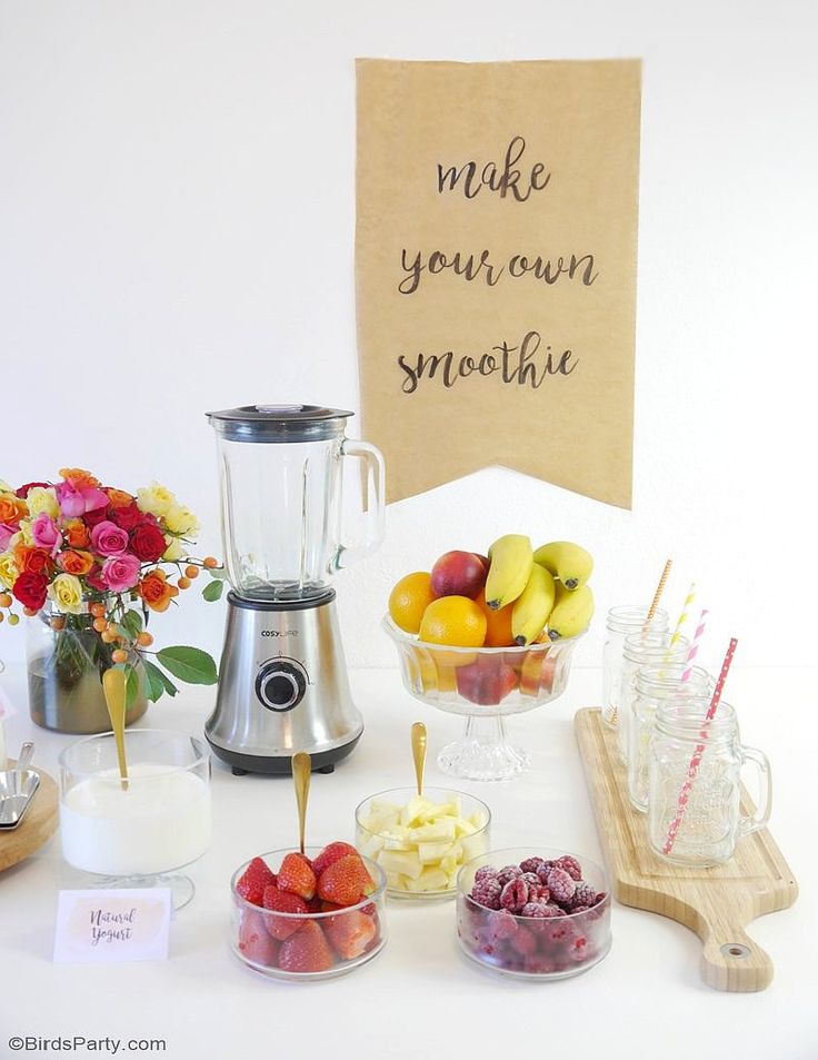 a table topped with fruit and drinks next to a sign that says make your own smoothie