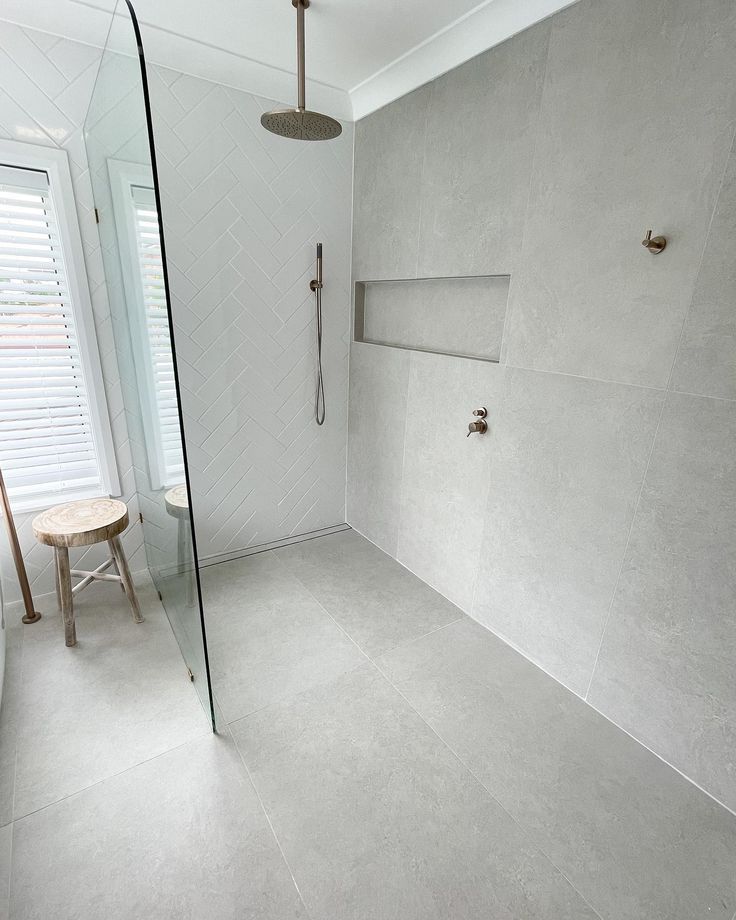 a bathroom with a walk in shower next to a window