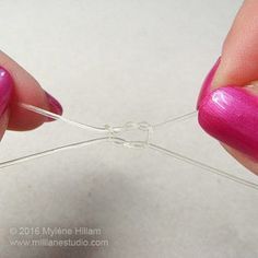 someone is working with some wire to make something pinky and bright purple nail polish on their nails