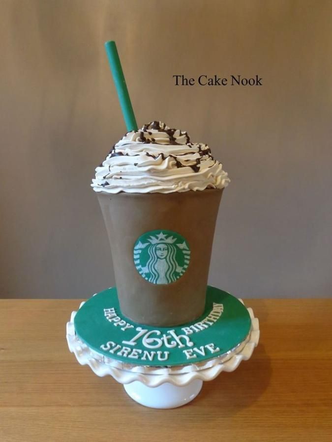 a starbucks cup cake on top of a table with a green straw sticking out of it