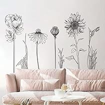 a living room filled with furniture and flowers on the wall