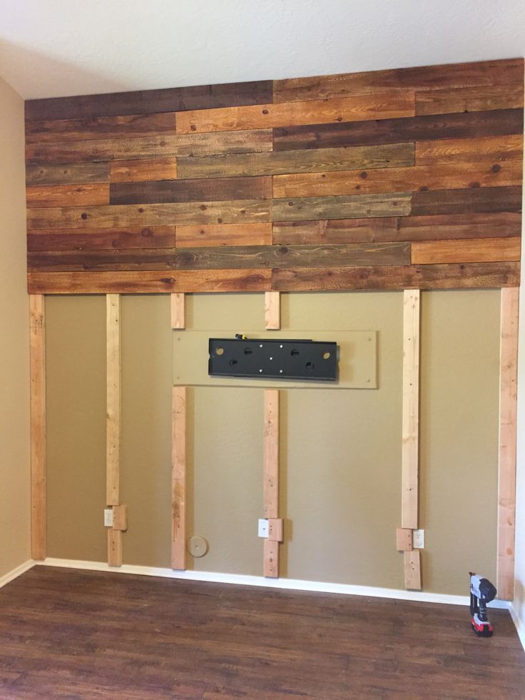 an empty room with wood paneling on the wall and electrical outlets in place