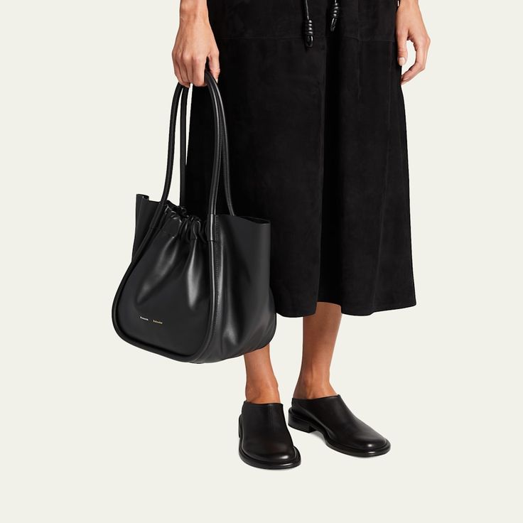 Proenza Schouler tote bag in smooth leather. Tubular shoulder straps with ruching at base, 7" drop; strap 21.5" drop Open top with magnetic closure. Includes leashed zip pouch. Approx. 7"H x 12.7"W x 5.1"D. Approx. weight 3.7 lb/1.7 kg. Made in Italy. Chic Calf Leather Shoulder Bag With Rolled Handles, Everyday Calf Leather Shoulder Bag With Rolled Handles, Chic Leather Bucket Bag With Rolled Handles, Leather Slides, Zip Pouch, Open Top, Proenza Schouler, 7 H, Leather Tote Bag