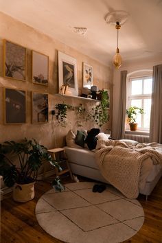 a living room filled with furniture and lots of plants on the wall next to a window