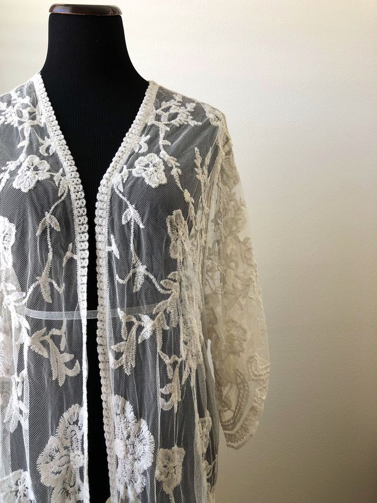 "This overlayering piece is made with soft embroidered sheer lace, features mid sleeve with scalloped sleeve edge and hem. Makes for a super sweet cover up for any outfit! ONE SIZE FITS MOST - SMALL, MEDIUM, LARGE Length: 37\" Bust: 23\" (open front, one size fits all) Armhole: 11\" Now when you order two items or more, your shipping is on us! Enter FREESHIP at checkout! ( US shipping only) And/Or Share your photo with me in the item you purchased, you will receive a $15 coupon toward your next Bohemian Floral Embroidered Open Front Kimono, Bohemian Open Front Kimono With Floral Embroidery, Bohemian Long Sleeve Kimono With Chikankari Embroidery, Bohemian Long Kimono With Intricate Embroidery, Bohemian Kimono With Chikankari Embroidery For Spring, Bohemian Chikankari Embroidered Kimono For Spring, Bohemian Chikankari Kimono For Spring, Bohemian Fitted Sheer Cover-up, Bohemian Kimono With Intricate Embroidery