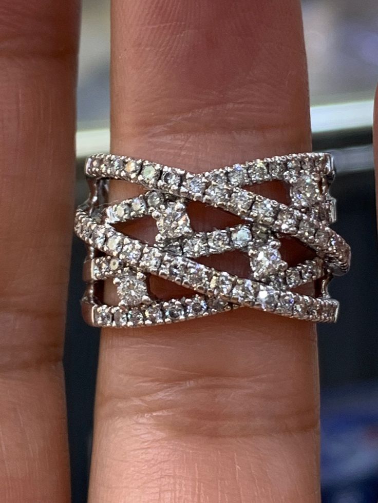 a woman's hand with a diamond ring on top of her finger and the other hand holding it