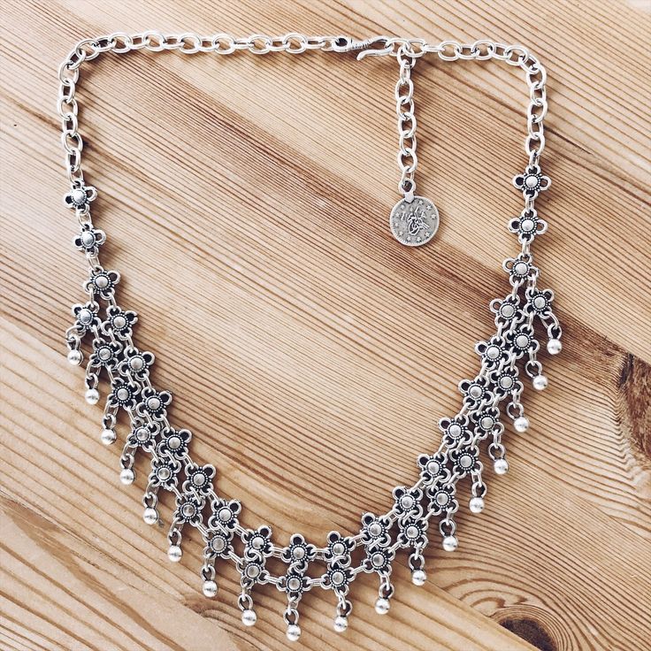 Our Anatolian Droplet Necklace features round droplet beads dangling on the ends of a double-decker web of engraved sunshine beads, giving it a chainmail pattern. A rolo/cable chain allows this statement-worthy bib necklace to sit centered when worn, secured with a hook clasp for elegance. Handcrafted in Istanbul by local artisans Measurements: Total length 50cm (adjustable to the desired length), length from top of chain to bottom 3cm. Materials: Silver-plated zinc alloy Bohemian Drop Necklace With Beaded Chain, Dangle Chain Necklace For Festivals, Bohemian Beaded Dangle Chain Necklace, Bohemian Dangle Beaded Chain Necklace, Bohemian Metal Necklaces With Dangling Beads, Bohemian Dangle Chain Necklace With Adjustable Chain, Dangle Metal Chain Necklace For Festivals, Bohemian Metal Layered Necklace With Beaded Chain, Bohemian Metal Choker With Dangle