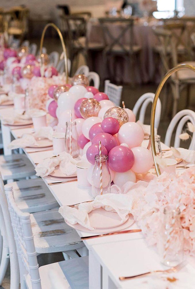 the table is set with pink and white balloons