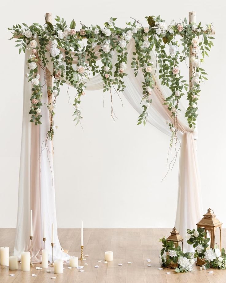 a wedding arch decorated with flowers and greenery for an outdoor ceremony in the middle of a wooden floor