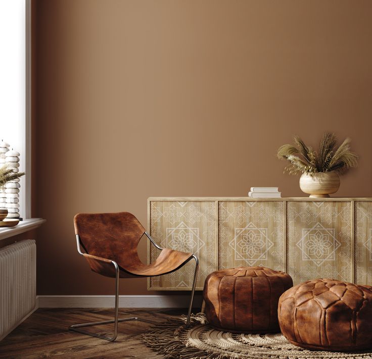 a living room with brown walls and leather foot stools in front of a wooden cabinet