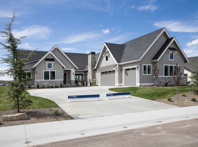 a large house with two blue benches in front of it and grass on the side