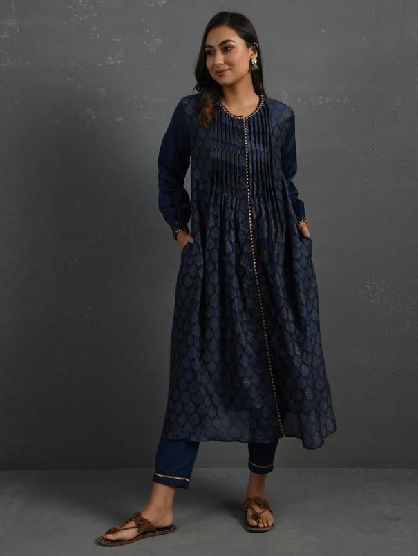 A gold hand block printed front open chanderi kurta with pintucks, gota details, full-length sleeves with gathers. This indigo kurta comes with a separate matching mul slip and pants with elasticated and drawstring adjustable waistband Kurta measurements (in Inches): Size S: Bust - 39", Waist - 39" Size M: Bust - 42", Waist - 42" Size L: Bust - 45", Waist - 45" Length: 47", Sleeve length: 21" Pant Measurements (in Inches): Size S: Waist - 30-32" Size M: Waist - 33-35" Size L: Waist - 36-38" Leng Eid Straight Kurta With Pintucks, Festive Indigo Sets With Block Print, Eid Pintucks Straight Kurta, Festive Indigo Block Print Set, Indigo Straight Kurta Designer Set, Indigo Long Sleeve Set For Festive Occasions, Indigo Designer Straight Kurta, Designer Indigo Straight Kurta, Indigo Designer Wear Straight Kurta