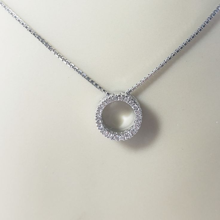 Vintage 14 Karat White Gold Diamond Circle Pendant Necklace- This sparkling circle pendant necklace features 22 round brilliant cut diamonds set in classic 14K white gold.   Approximate total diamond weight:   .22 ct. Diamond color:  I Diamond clarity:  I1-I2 Size:   17 inches  (necklace)            10 mm (pendant) Weight:   3.4 dwt. /   5.3 gr. Stamped: 14K Very good condition, professionally polished. Will come packaged in a gift box or pouch (when possible) and will be shipped U.S. Priority Mail Insured. DV061322/17KCS Classic Circle Jewelry With Diamond Accents, Diamond White Platinum Round Diamond Necklace, Round Diamond White Platinum Necklace, Diamond Jewelry With Halo Setting In Round Pendant, Diamond Round Pendant Jewelry With Halo Setting, Platinum Diamond White Round Diamond Necklace, Dazzling Round Diamond Necklace With Cubic Zirconia, Round Diamond Cut Necklace, White Gold Diamond Necklace With Halo