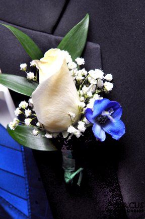 a boutonniere with white and blue flowers on it's lapel