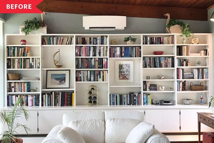 a living room filled with lots of white furniture and bookshelves full of books