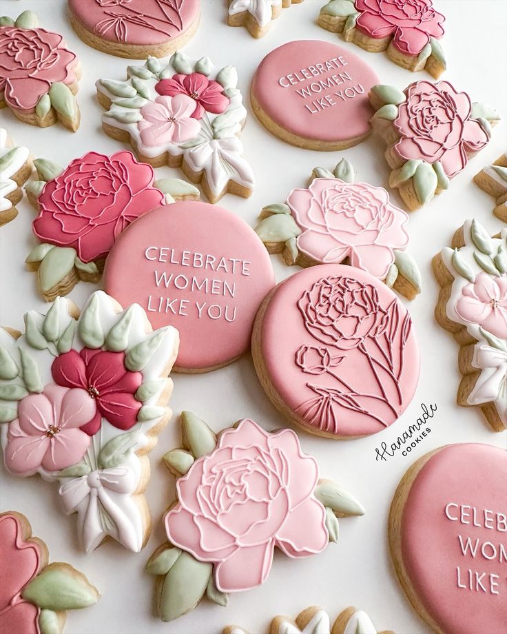 decorated cookies with words and flowers are on a white tablecloth that says celebrate women like you