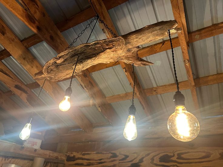 several light bulbs hanging from the ceiling in a room with wood beams and exposed ceilings