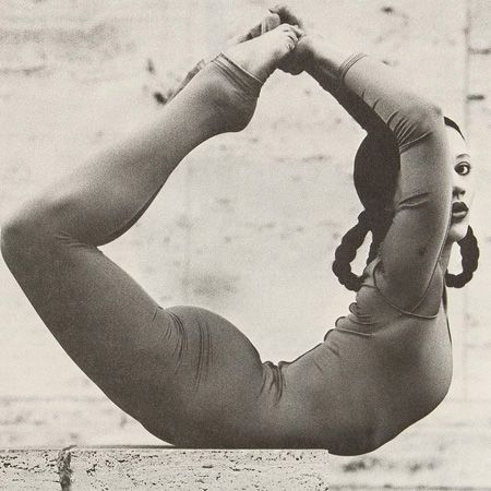 an old black and white photo of a woman doing yoga exercises with her hands behind her head