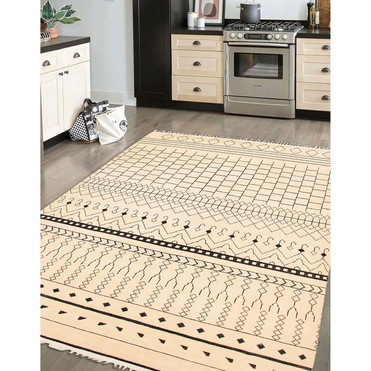 a kitchen with an oven, stove and rug on the floor in front of it