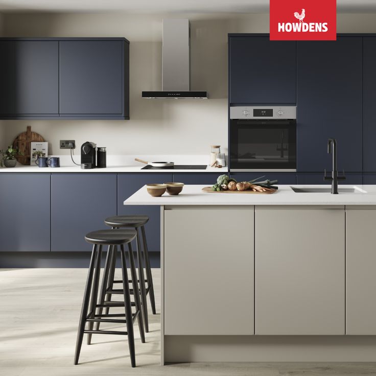 an image of a kitchen setting with blue cabinets and white counter tops that has two stools in front of the island