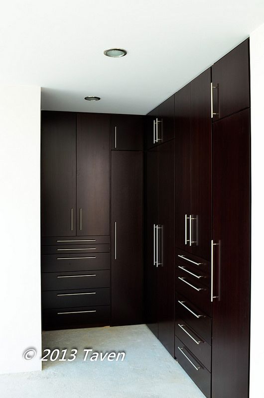 an empty room with wooden closets and white carpeted flooring in the middle