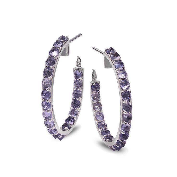 Hoop earrings set in sterling silver with 4.27cts iolite and 0.01cts diamond accent. Hoop diameter measures 1 inch. Modern Sterling Silver Hoop Earrings With Prong Setting, White Gold Gemstone Hoop Earrings, Fine Jewelry Sterling Silver Hoop Earrings With Gemstone, Sterling Silver Hoop Earrings With Gemstones, Silver Hoop Earrings With Gemstones In Fine Jewelry Style, Silver Gemstone Hoop Earrings Fine Jewelry, Sterling Silver Gemstone Hoop Earrings, White Gold Hoop Earrings With Gemstones In Sterling Silver, White Gold Sterling Silver Hoop Earrings With Gemstones