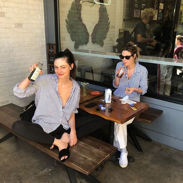 two women sitting at a table with drinks