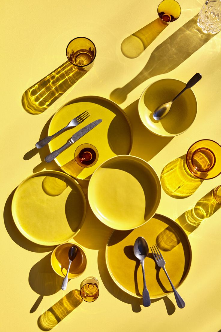 yellow plates and utensils are arranged on a table