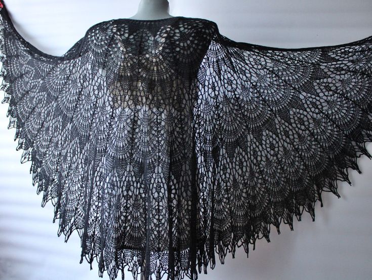 a black lace shawl hanging on a white wall