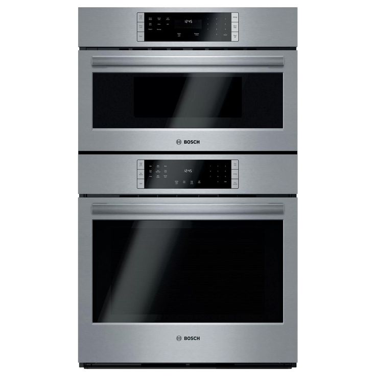 two stainless steel ovens side by side on a white background with the door open