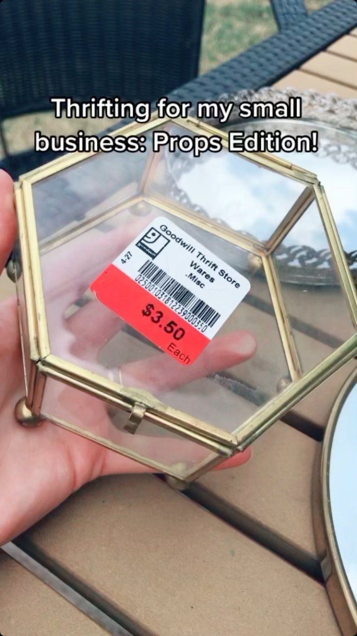 a person holding a small glass box with a price tag on it that says,'thrifting for my small business prop